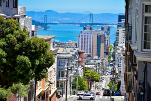 A Hilly street in San Francisco with the Oakland Bay Bridge